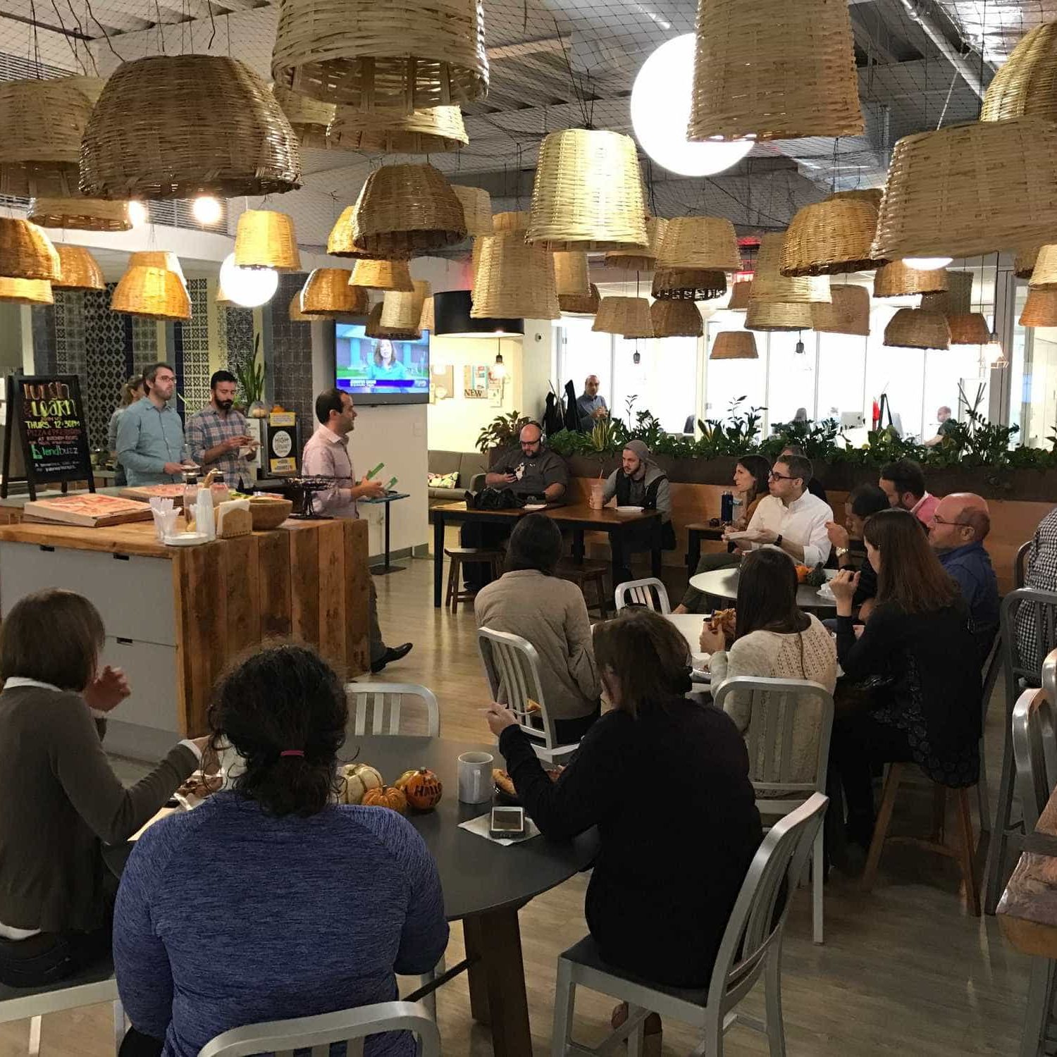 Many NGIN Workplace team members sitting and watching a member show and tell